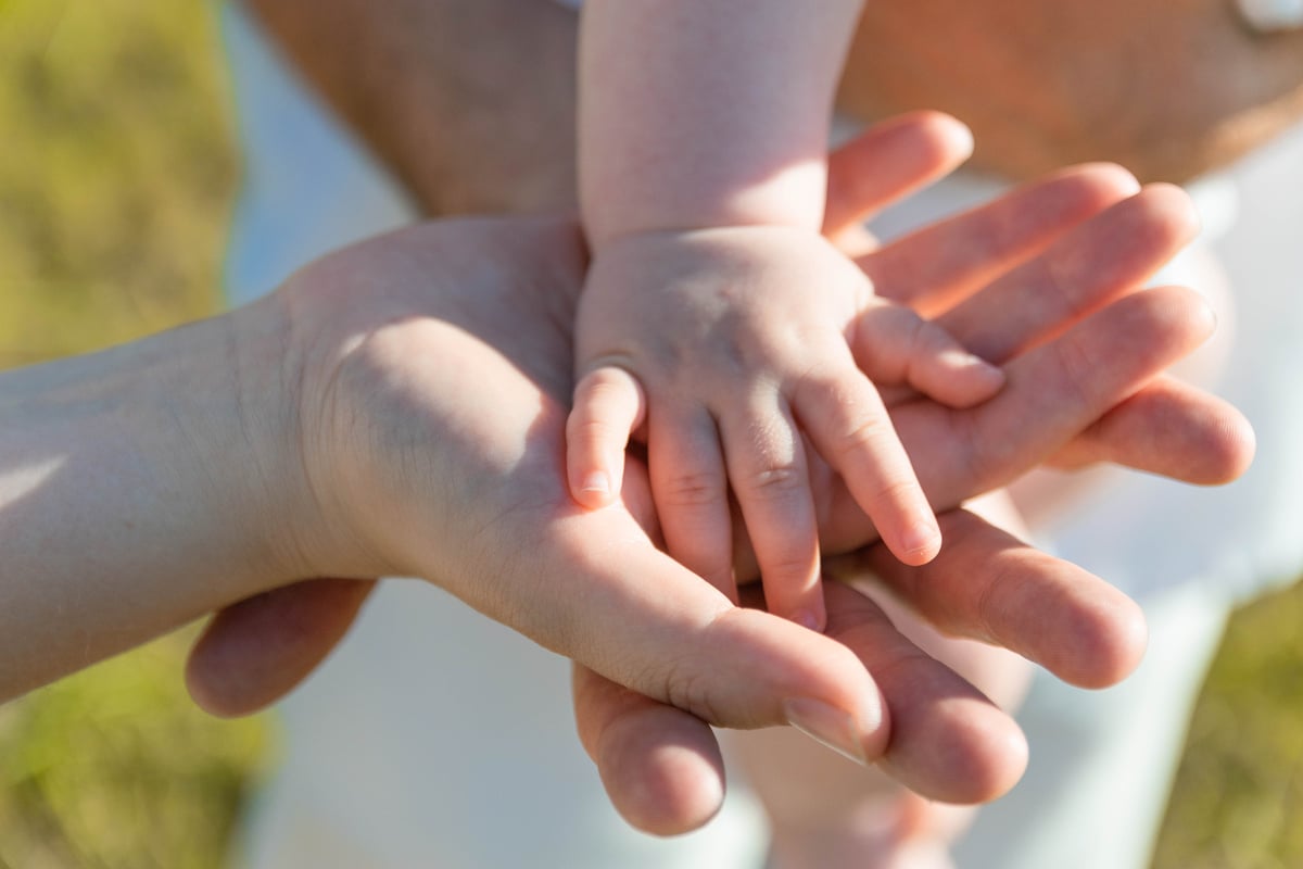 Close-up Photo of Baby's Hand on Parent's Hands